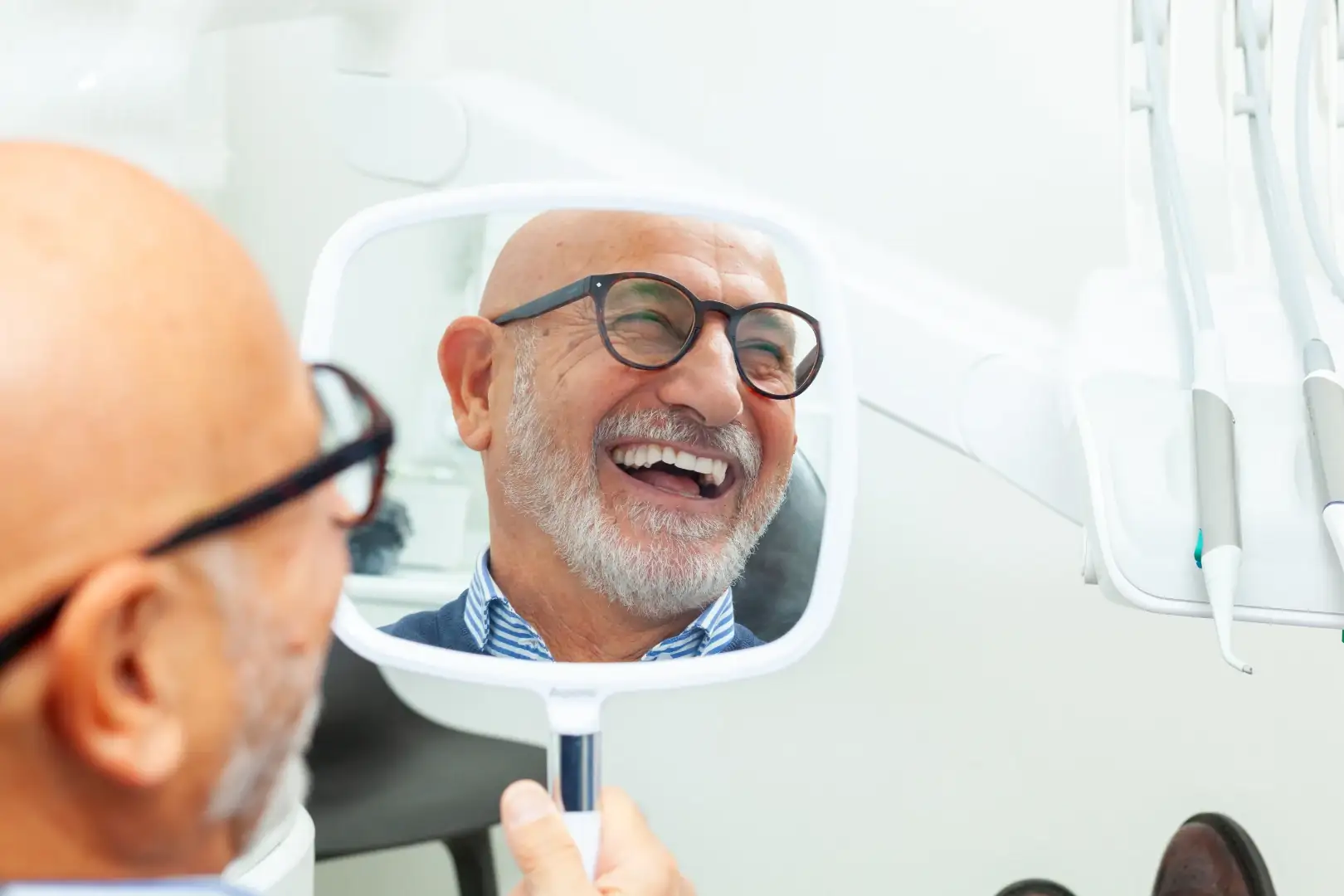 Older patient smiling confidently after dental implant treatment in Woodland Hills