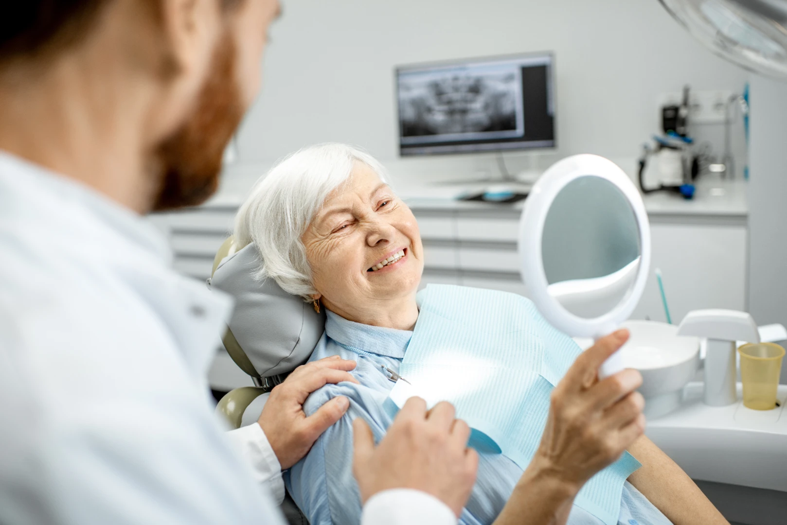 Mature patient smiling with a full set of restored teeth