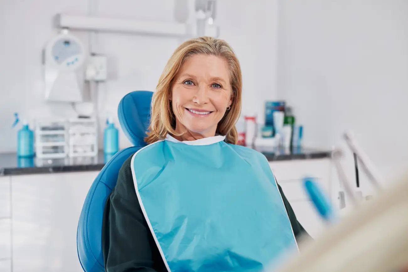 Long-time First Dental Implant Center patient smiling in the practice